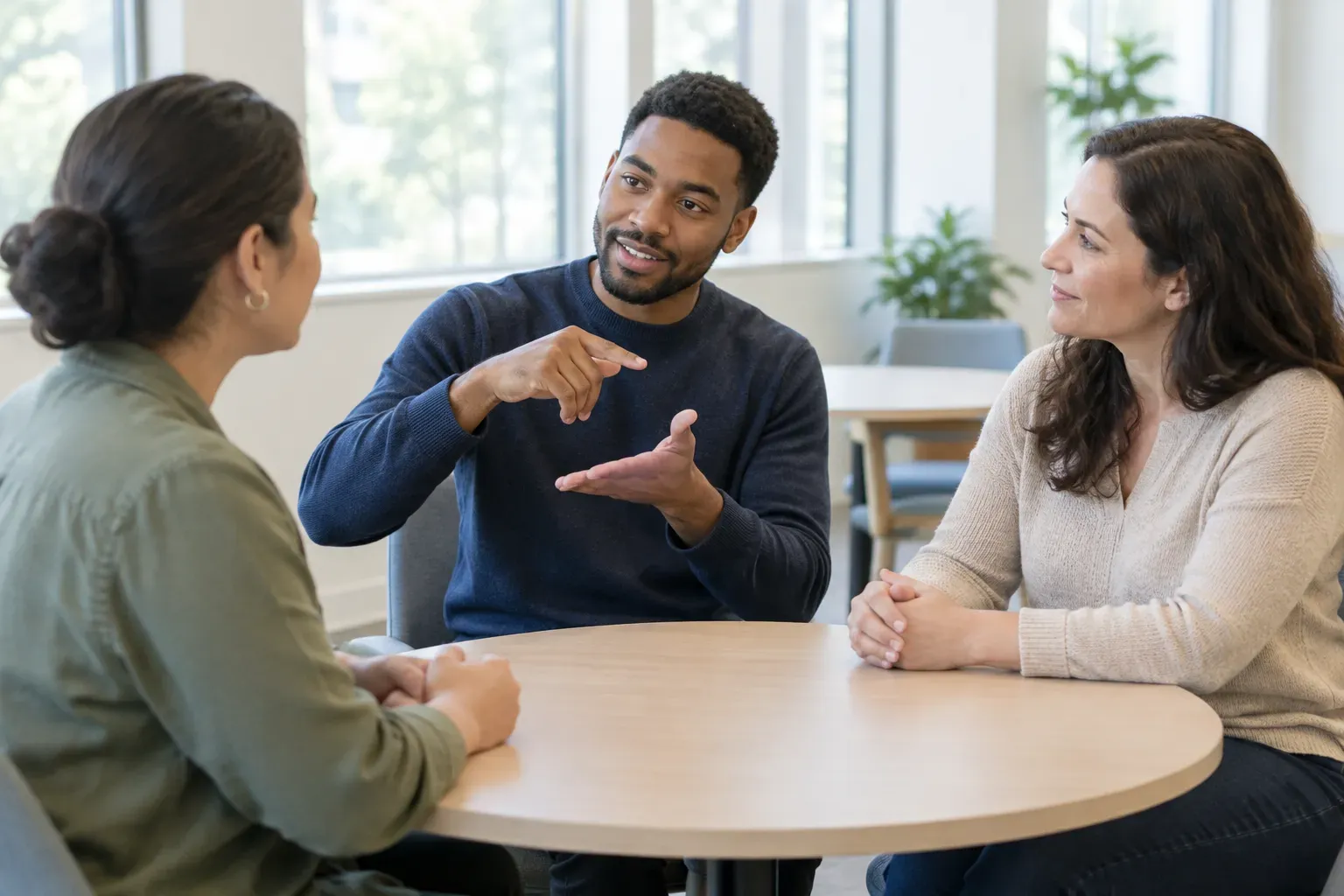Three people at a table in a signed discussion